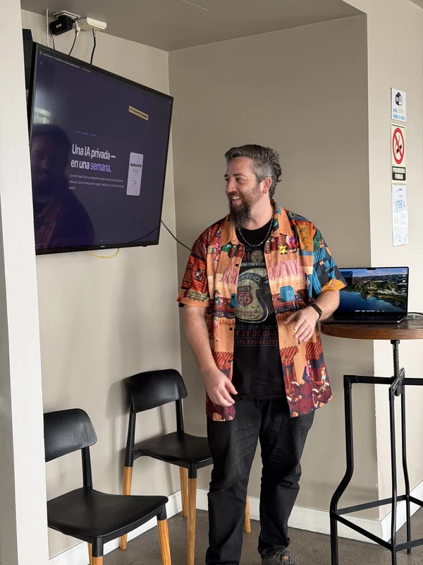 A teammate presenting beside a wall-mounted screen