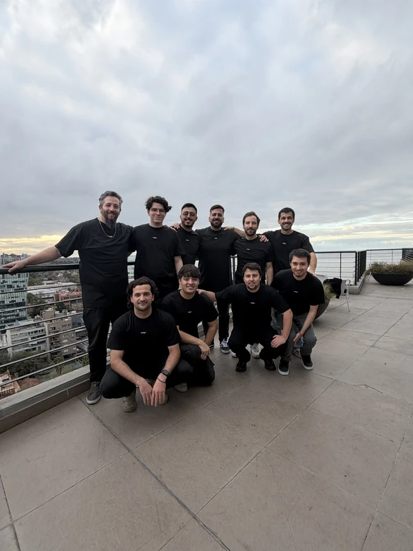 The team posed together on a rooftop terrace under an overcast sky